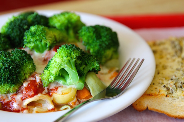 Fresh steamed broccoli atop cheese tortellini.