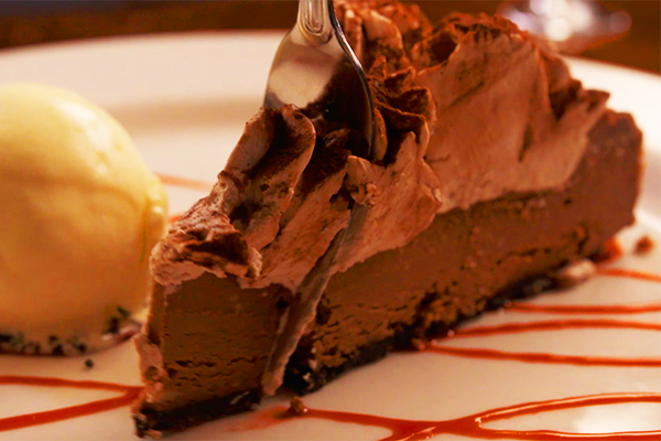 This chocolate cheesecake is made by their house pastry chef and served with a refreshing scoop of ice cream and caramel drizzle.