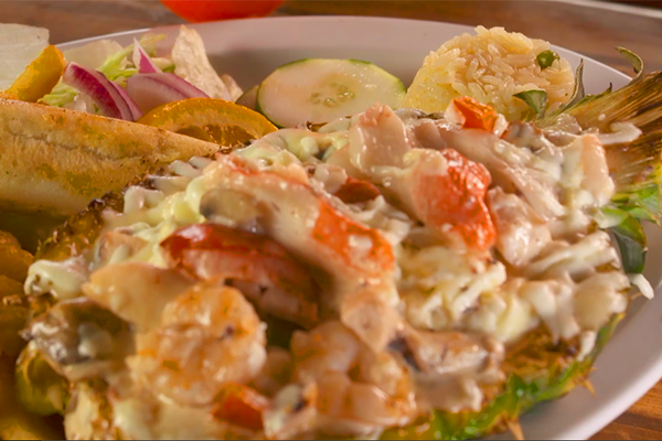 This seafood dish is called Pina Rey, which translates to pineapple king. Pineapple is stuffed with costena mix and covered in heavy cream and cheese.