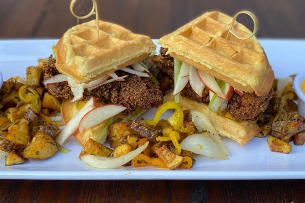 Clues and Cocktails - Chicken Tenders On A Belgian waffle, With Geechee Potatoes | Photo: Facebook/cluesandcocktails