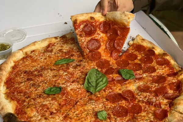 Pizza pie with a slice of pepperoni being lifted