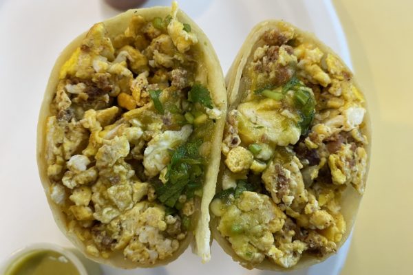 A breakfast burrito cut in half and stuffed with eggs, chorizo, and more