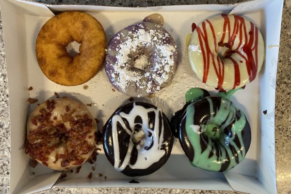 Six donuts of varying colors and toppings
