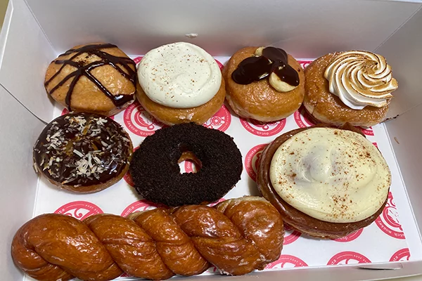 Eight pastries, including six donuts, a cinnamon bun, and a long twist