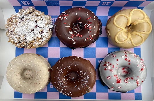 Six donuts of varying colors and toppings