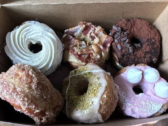 Six donuts of varying colors and toppings