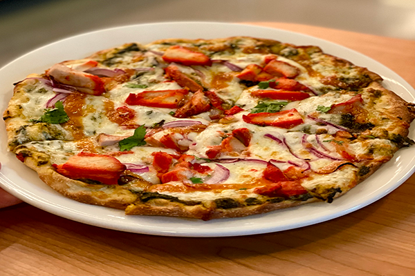 Pizza on naan with chicken tandoori, cilantro, onions, and more