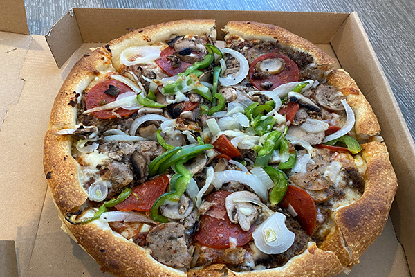 A pizza topped with meats, veggies, and more