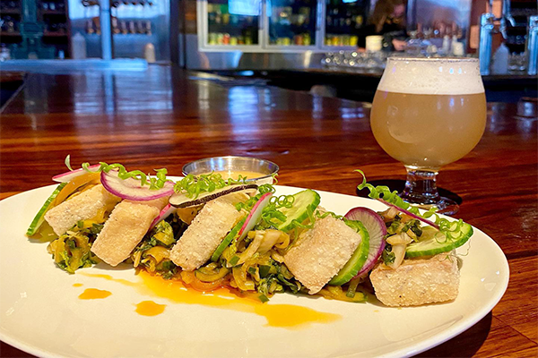 Tofu dish with beer in background