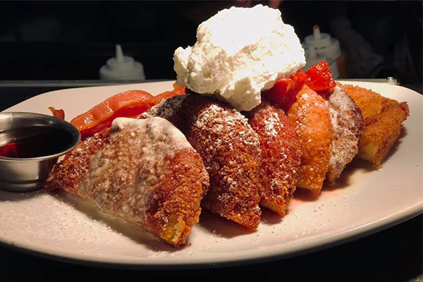 Fried cheesecake empanadas with strawberry on top