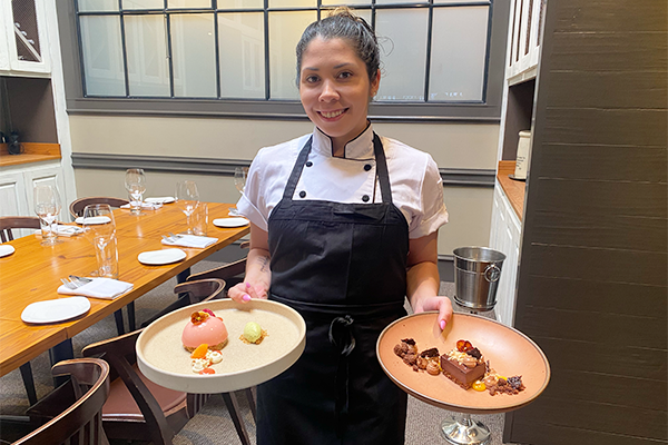 Woman holding two desserts on plates