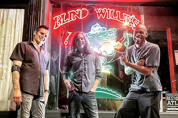Blues/Rock trio Hughes Taylor in front of Blind Willies.