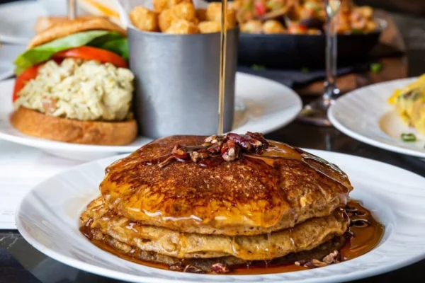 Delicious pancakes with drizzle of warm maple syrup