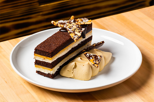 Multi-layered candy bar with caramel, shortbread, chocolate, creme fraiche, and more