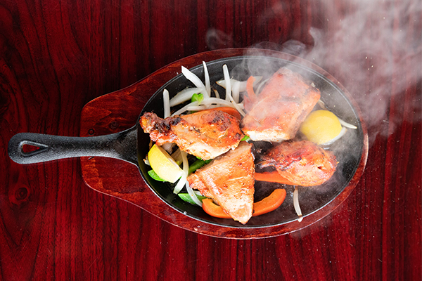 Sizzling pan of bone-in chicken and veggies