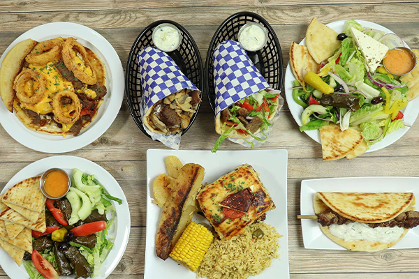 Multiple Greek dishes: platters, salads, and pitas