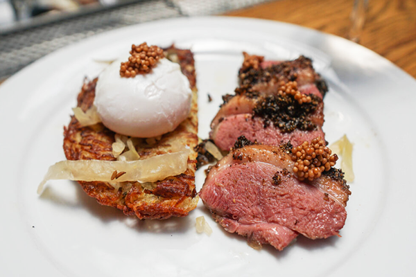 Duck pastrami and potato pancake topped with poached egg and whole grain mustard