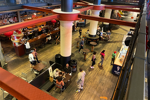 Overhead shot of food hall with customers ordering, sitting, and walking