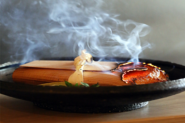 A sizzling piece of sea bass on a black platter