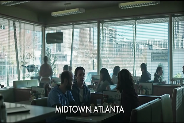 A group eating in a diner with the words "Midtown Atlanta" written in the center