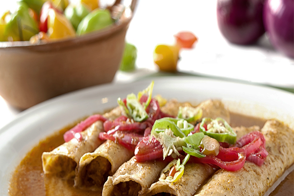 Plate of taquitos with garnish on top