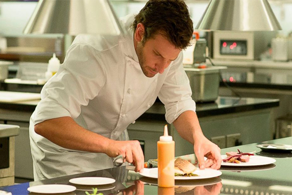 Bradley Cooper as a chef preparing a plate