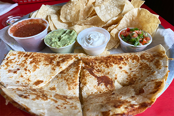 Quesadilla with several sauces and tortilla chips