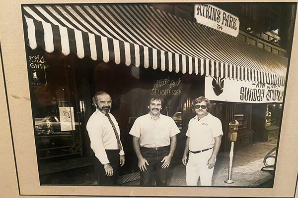 A black and white photo of three men standing in front of Atkins Park Tavern