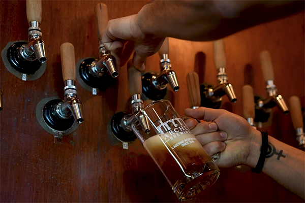 Bartender taps beer at Arches Brewing in Atlanta, GA