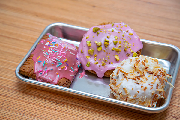 A variety of frosted pastries on a silver tray